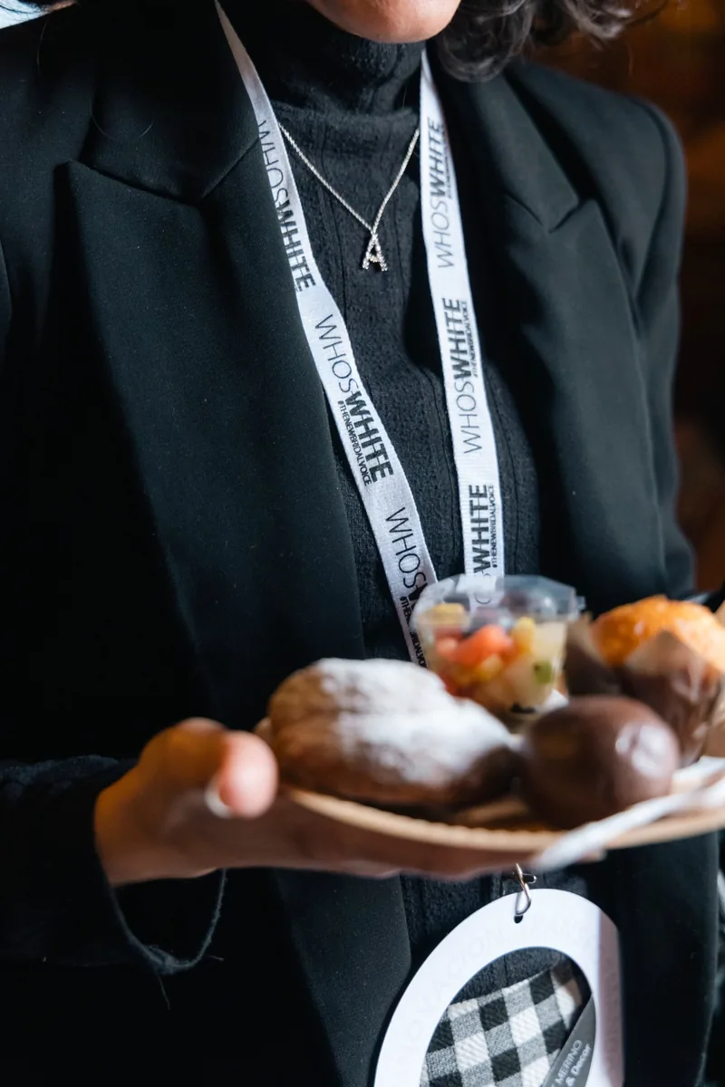 Guest holding a plate of pastries and fruit at an event breakfast